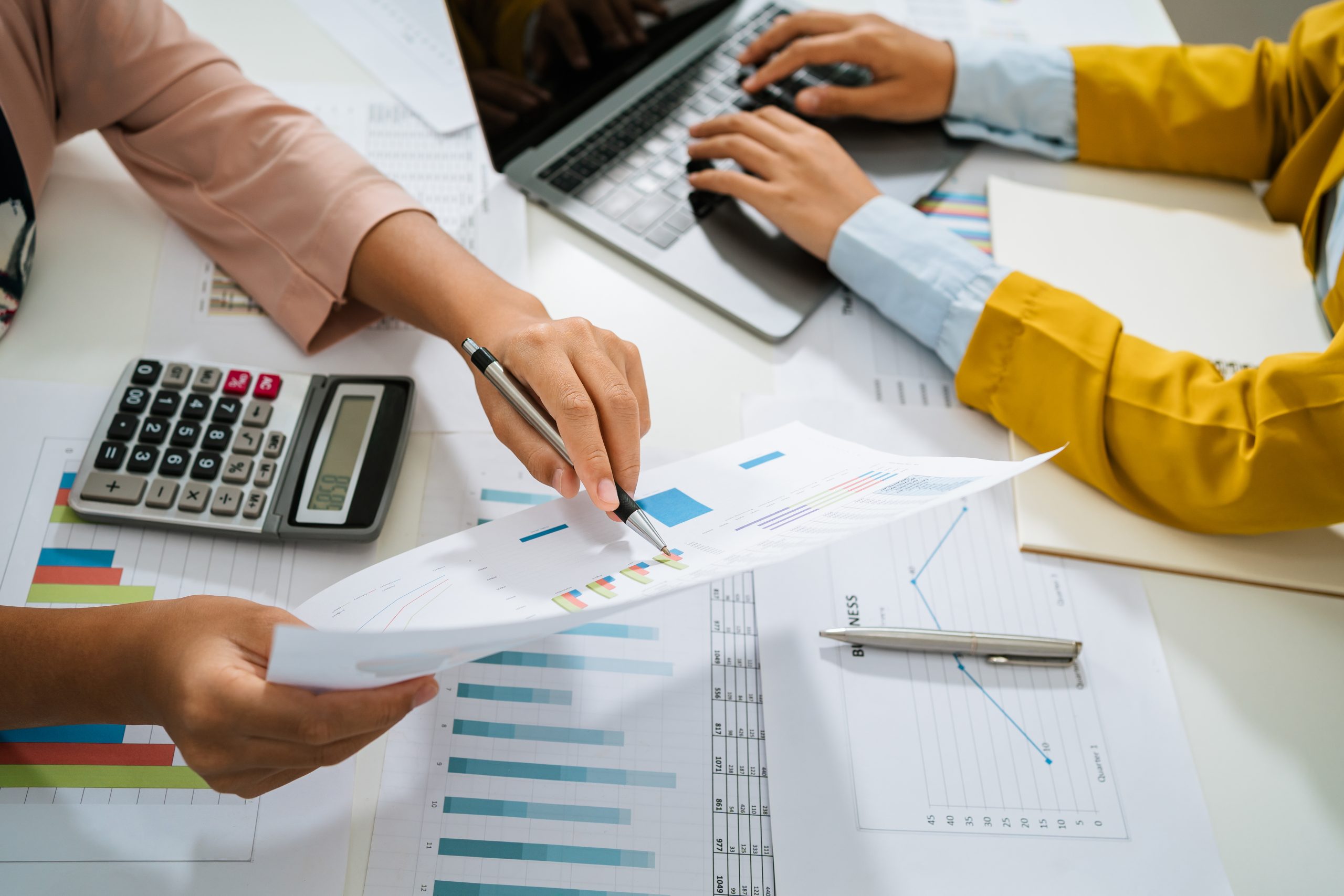 accountant  pointing on laptop for meeting team in office room.