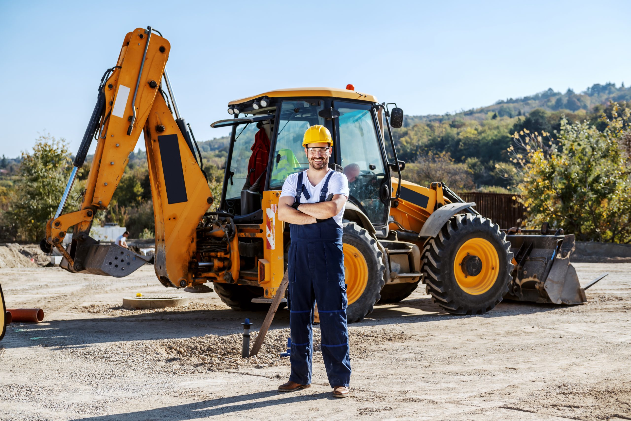 Handsome caucasian worker in overall and helmet on head standing